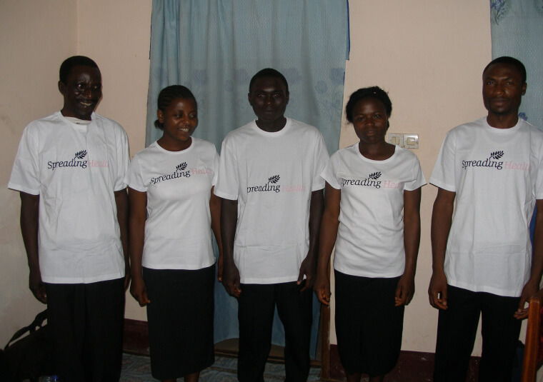 5 African nurses smiling, all wearing white 